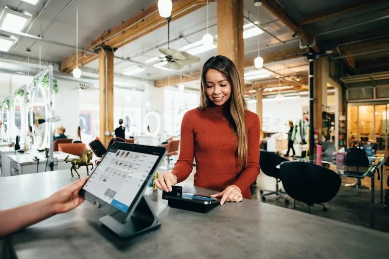 Shop owner taking payment at the counter while an AI agent sends the Google reviews request — 2026 guide